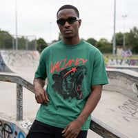 T-shirt oversized vert a l'imprime lion rugissant, porte au bord d'un bowl en beton couvert de tags