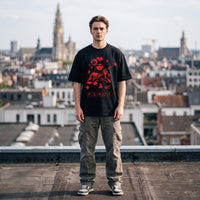 T-shirt oversized noir à illustration rouge anti guerre, porté sur un toit avec la cathédrale d'Anvers en fond