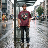 Coupe oversized bordeaux et imprimé gorille roi du poker, portée sous la pluie devant un abribus en verre