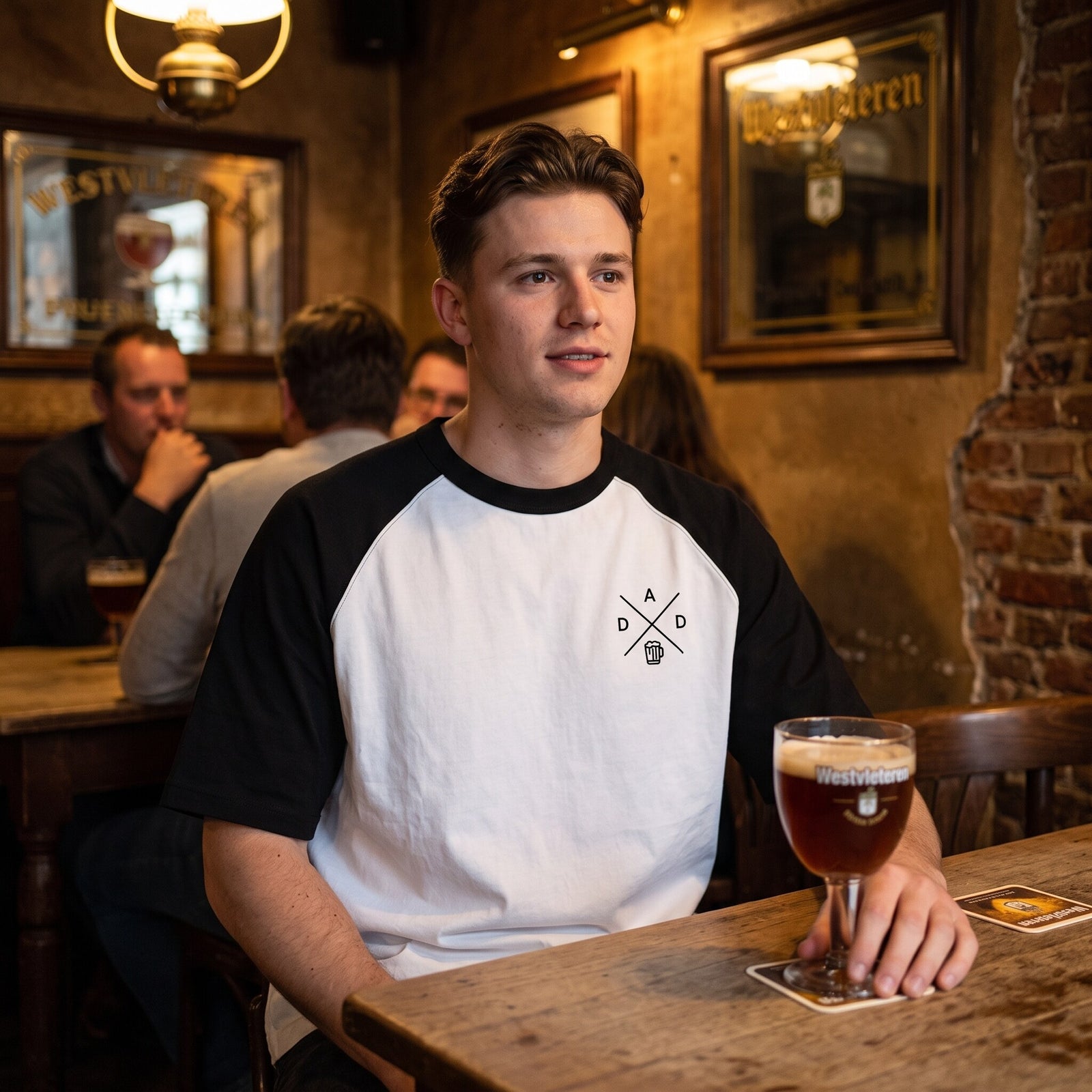 T-shirt raglan blanc et noir DAD Beer, porte attable dans un cafe brun belge devant un verre de biere