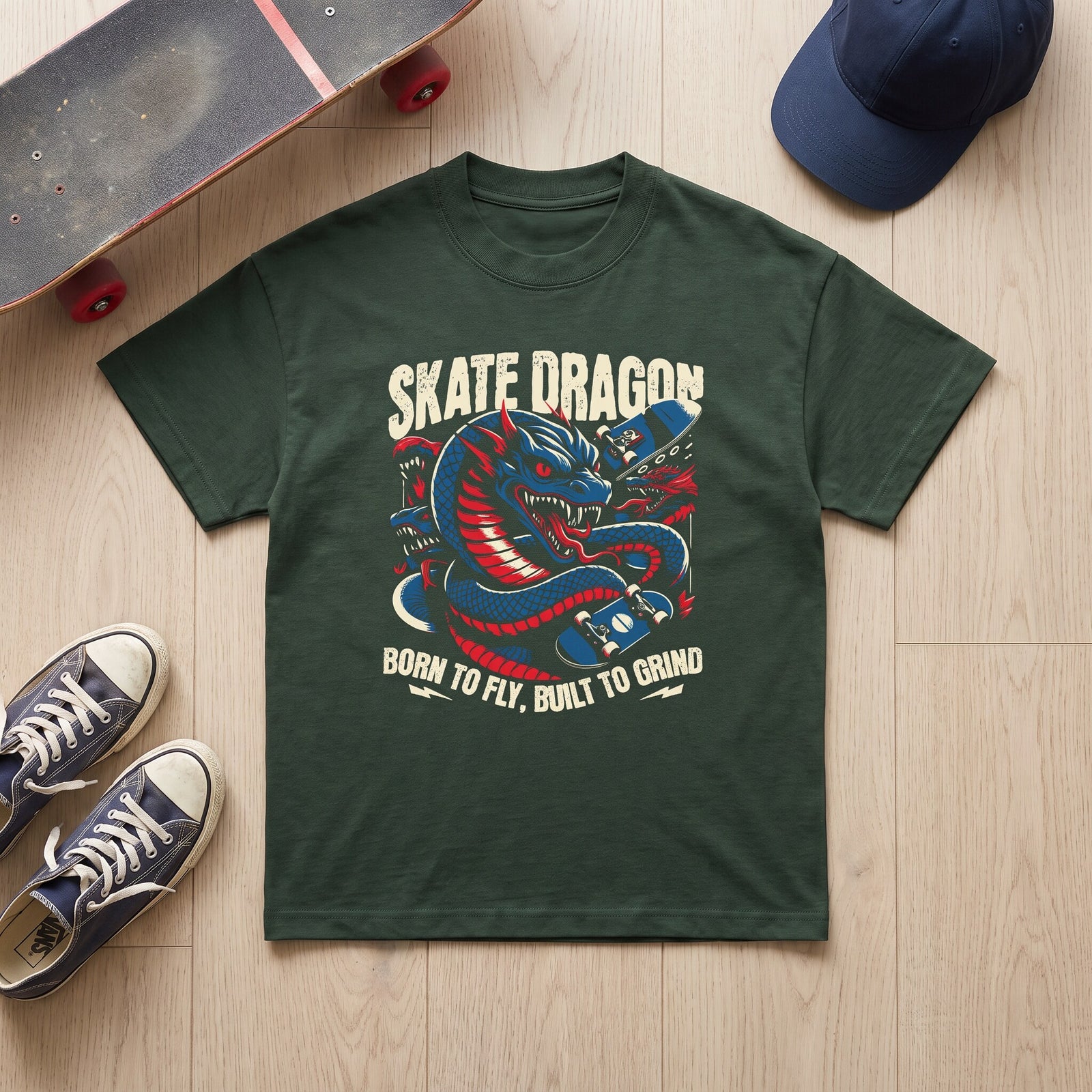T-shirt Skate Dragon vert fonce a plat sur parquet, planche au grip use, casquette bleu marine et baskets Vans
