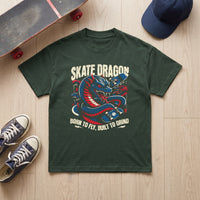 T-shirt Skate Dragon vert fonce a plat sur parquet, planche au grip use, casquette bleu marine et baskets Vans