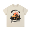 T-shirt enfant beige avec design vintage Mountain Expedition, illustration montagne orange avec sapins et soleil couchant, style outdoor rétro