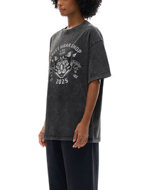T-shirt oversized belge noir délavé porté de trois quarts - blason chat et flèches croisées