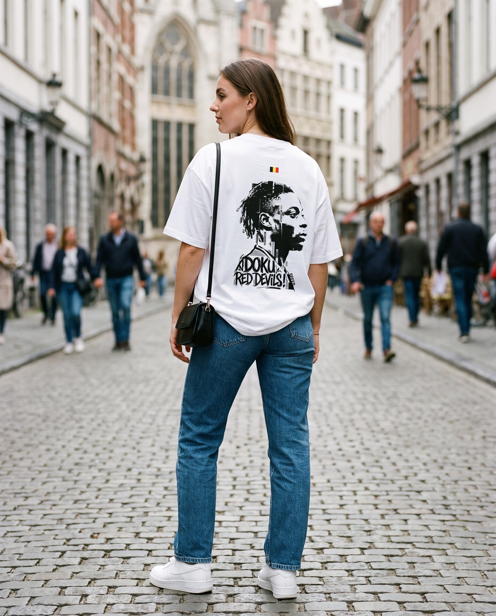 T-shirt oversized Jeremy Doku blanc porté par une supportrice des Diables Rouges en ville, vue de dos