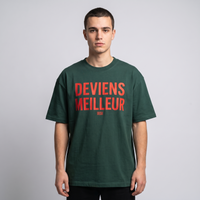 T-shirt oversized vert forêt Deviens Meilleur porté en studio, lettrage rouge sur la poitrine