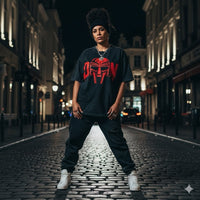 T-shirt oversized hommage MF DOOM en noir porté en extérieur - print rouge et coupe à épaules tombantes