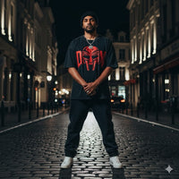 T-shirt oversized hommage MF DOOM en noir porté de nuit en ville - masque rouge XXL sur la poitrine
