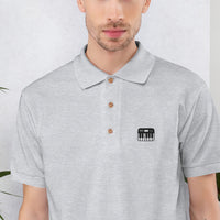Broderie clavier de piano en gros plan sur le polo gris sport